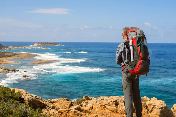 Wanderer mit Rucksack am felsigen Ufer — Stockfoto