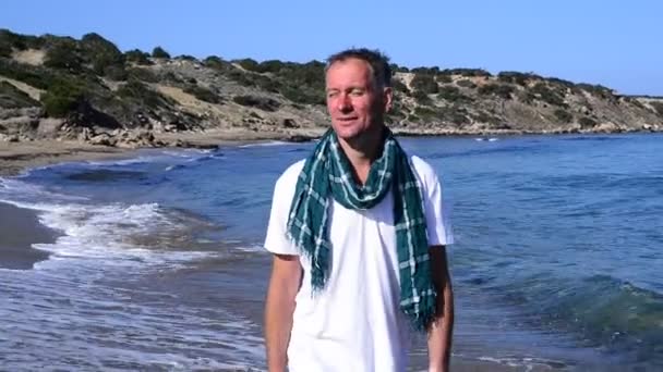Gelukkig man wandelaar gaat langs de zee — Stockvideo