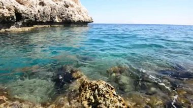 Şeffaf turkuaz Denizi kayalık kıyıya yakın yerde su sıçramalarına