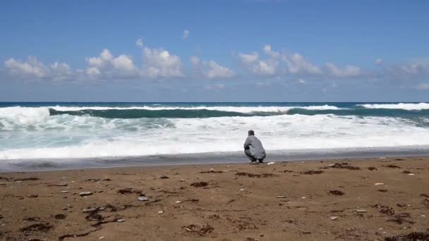 Man looks at the waves of the sea — Stock Video