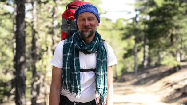 Caminante sonriente barbudo con una mochila — Vídeos de Stock