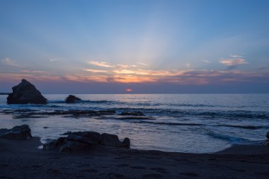 Lone rock, gün batımı sıçramasına dalgalar