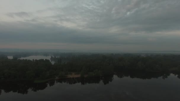 Pobřeží velké řeky v mlze během svítání, město na obzoru — Stock video