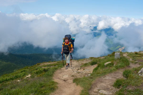 Backpacker поднимается на вершину — стоковое фото