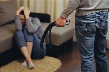 Alkolik koca karısını kemerle dövüyor. Zhenzhina elleriyle kendini kapatıyor. Aile içi şiddet