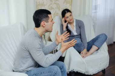 Koca karısına bağırıyor, kadın üzgün.