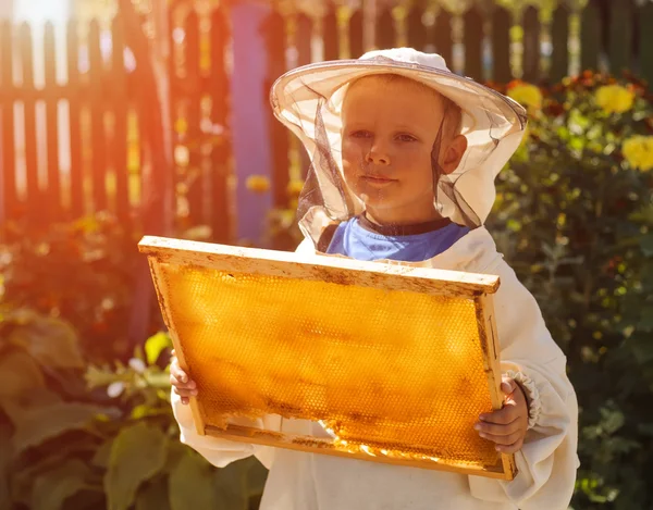 Νέος μελισσοκόμος αγόρι κρατάει καρέ του κηρήθρα — Φωτογραφία Αρχείου