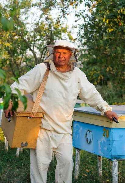 Retrato de um apicultor no apiário da colmeia — Fotografia de Stock