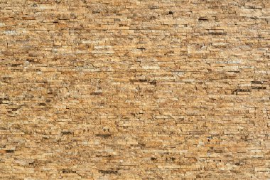 Farklı boyutlarda taştan duvarlar. Evin dış görünüşü.