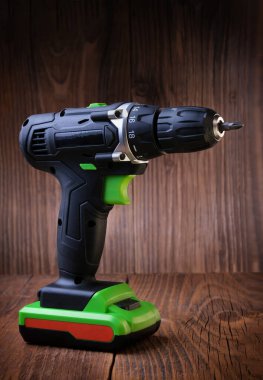 Kırsal ahşap arka planda elektrikli tornavida. Kablosuz matkap. Bakım evi kavramı. Metin için boşluk