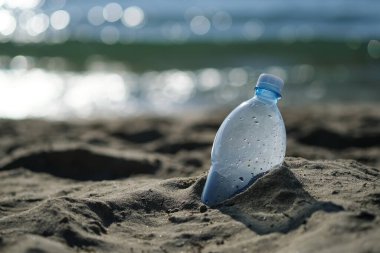 Plastik şişe plajda, turistten ayrıldı. Okyanusların sularının plastikle kirlenmesi sorunu. Plastiği terk etme kavramı