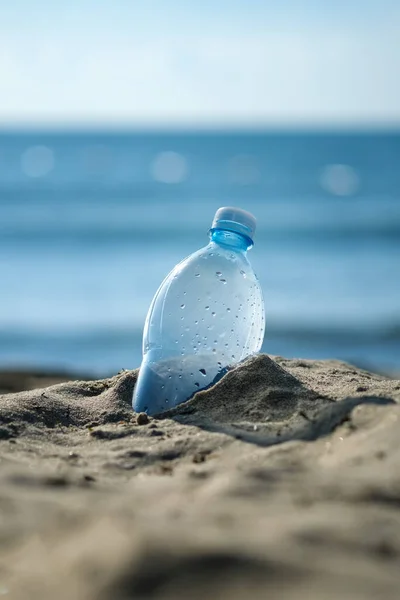 Plastic bottle is on the beach leave by tourist. The problem of pollution of the waters of the oceans with plastic. The concept of abandoning plastic