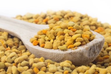 Çiçek arısı poleni ve tahta kaşık. Bağışıklık sistemini geliştirmek için doğal bir ilaç. Arıcılık ürünleri. Apioterapi