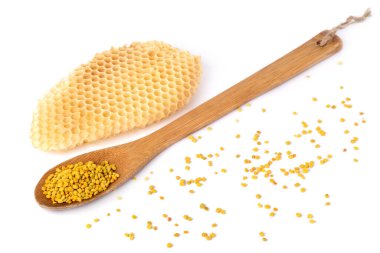 Tahta kaşıkta arı poleni ve beyaz arka planda bal peteği. Arıcılık ürünleri. Apioterapi