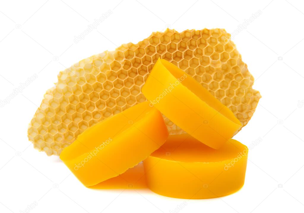Yellow natural bee wax with a piece of honey cell on a white background