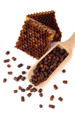 Arı granülleri ve bir parça bal hücreleri beyaz arka planda izole edilir. Bağışıklık sistemini geliştirmek için doğal bir ilaç. Arıcılık ürünleri. Apioterapi