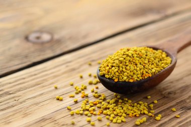 Arı poleni kaşık içinde ahşap arka planda. Sağlıklı organik çiğ diyet vejetaryen besin maddesi - arı poleni. Arıcılık ürünleri. Apioterapi