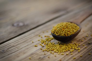 Arı poleni kaşık içinde ahşap arka planda. Sağlıklı organik çiğ diyet vejetaryen besin maddesi - arı poleni. Arıcılık ürünleri. Apioterapi