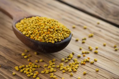 Arı poleni kaşık içinde ahşap arka planda. Sağlıklı organik çiğ diyet vejetaryen besin maddesi - arı poleni. Arıcılık ürünleri. Apioterapi