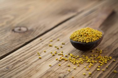 Arı poleni kaşık içinde ahşap arka planda. Sağlıklı organik çiğ diyet vejetaryen besin maddesi - arı poleni. Arıcılık ürünleri. Apioterapi