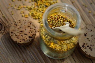 Kavanozda arı poleni ve tahta masada tahta kaşık. Apioterapi. Arı ürünleri