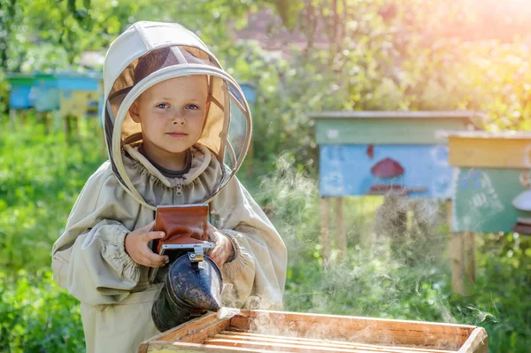 その少年養蜂家は巣の養蜂場で働いている 4月だ Apiculture — ストック写真