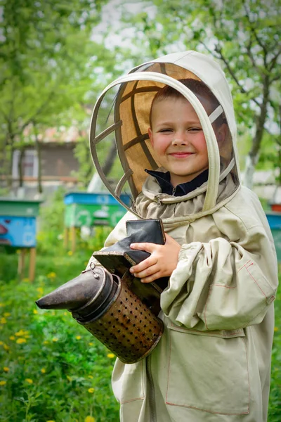 保護服の養蜂家の少年は猿の上で働く — ストック写真