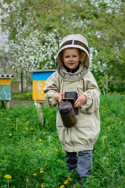 保護服の養蜂家の少年は猿の上で働く — ストック写真