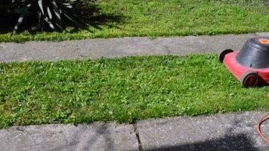 Elektrikli çim biçme makinesi onun bahçesinde biçme adam