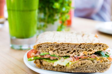 Sandviç serviert ile güler yüzlü ahşap tablo.