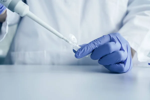 Mãos de um cientista que trabalha com pipeta e um tubo de ensaio. Técnico de pesquisa no laboratório genético — Fotografia de Stock