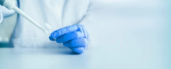 Pipet ve test tüpüyle çalışan bir bilim adamının elleri. Genetik laboratuarında araştırma teknisyeni. tıbbi ve araştırma pankartı
