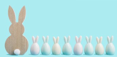Paskalya bayrağınız kutlu olsun. Mavi pastel arka planda renkli Paskalya tavşanları. Kopya alanı olan Paskalya tebrik kartı veya web sınırı