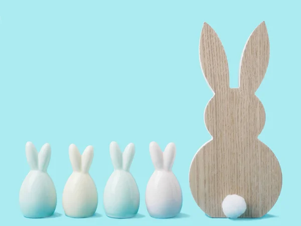 Conejos de Pascua de colores sobre fondo pastel azul. Tarjeta de felicitación de Pascua o borde web con espacio para copiar Imagen De Stock