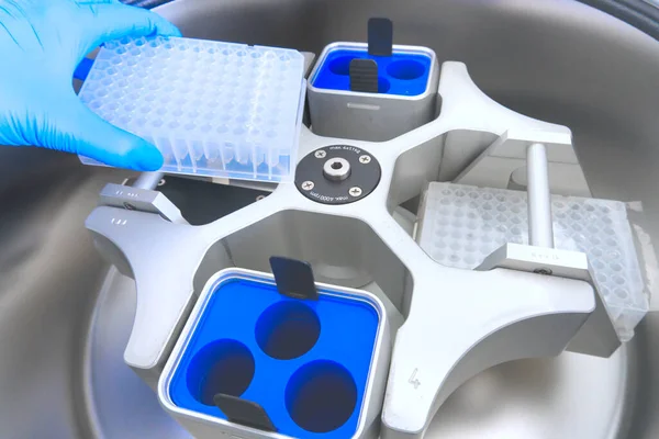 Bilim adamı test tüplerini santrifüje koydu. Klinik laboratuarında otomasyon. Robot laboratuarı borulama. Araştırma ve bilim geçmişi.