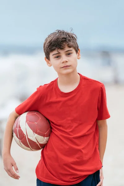 Çocuk plajda topla oynuyor. Deniz kenarında aile tatili.