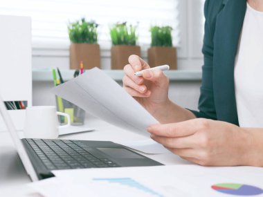 İş kadını büro masasındaki bir belgeye yazıyor. Ofisteki iş kadını ya da girişimci. Çevrimiçi iş, pazarlama veya öğrenme kavramı