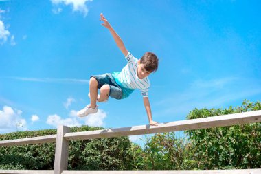 Çocuk çitten atladı. Gençler için spor ve aktiviteler. Çocukluk ve rahatlık. Özgürlük ve mutlu insanlar.