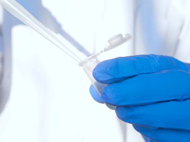 Laboratuvar araştırmacısı ya da hemşire pipet hasta örneğini test tüpüne koydu. Genetik mühendisliği ya da genetik hastalık taraması. Kanser ve uyuşturucu araştırmaları ve bilim.