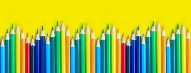 Sarı arka planda, kopya alanı olan kalemler. Okul ve renkli kalemlerle yaratıcı boya konsepti. Okula dönüş afişi