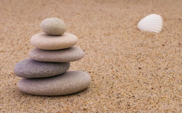 Spa stenar med skaldjur på sand — Stockfoto