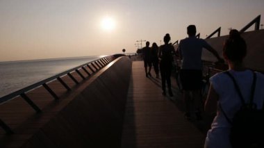 Izmir - Türkiye, Haziran 2016: Bostanlı, Karşıyaka, gün batımında güzel ahşap köprü üzerinde zevk insanlar