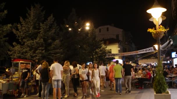 Bitola, Македонія - липень, 2015: Людей, що йдуть на головній вулиці Bitola вночі. Bitola є другого за величиною містом в Республіці Македонія. — стокове відео