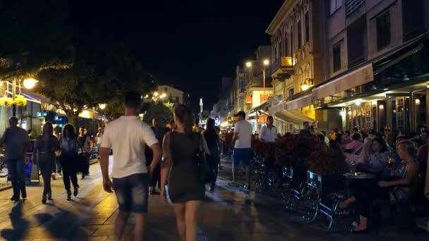 Bitola, Македонія - липень, 2015: Людей, що йдуть на головній вулиці Bitola вночі. Bitola є другого за величиною містом в Республіці Македонія. — стокове відео