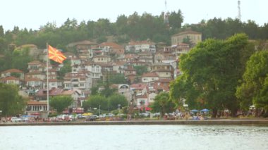 Ohrid, Makedonya, Haziran 2015: Deniz kenarındaki güzel görünümünü Ohri şehir ve Ohri Gölü'nden sallayarak büyük Makedon bayrak. Tarihi merkezi ve güzel göl, unesco listelenen için Ohri ünlüdür.