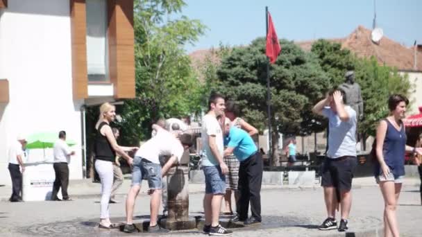 Prizren - Koszovó, 2015 júliusáig: Emberek ivóvíz city center tér keleti csapból. — Stock videók