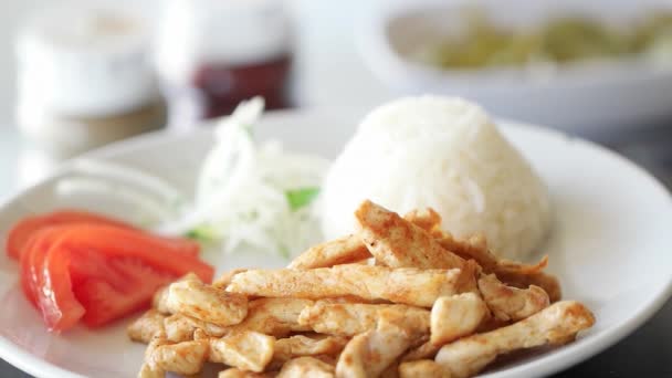 Pollo a la parrilla girando en cámara lenta en plato con arroz, cebolla y tomates . — Vídeos de Stock