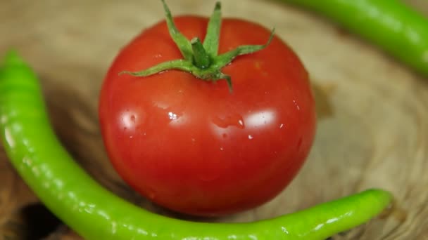 Tomato and green peppers on rotating wood. — Stock Video