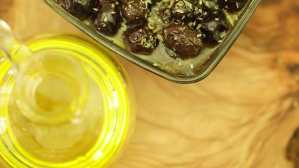Frische Thymianblätter auf schwarze Oliven mit natürlichem Olivenöl Flasche auf drehen — Stockvideo
