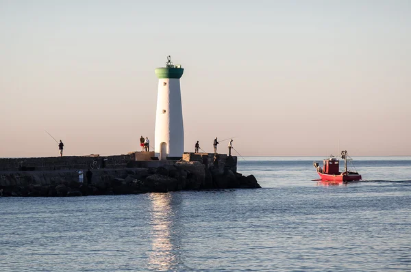 Fishermen at dawn around the lighthouse — Stock Photo, Image